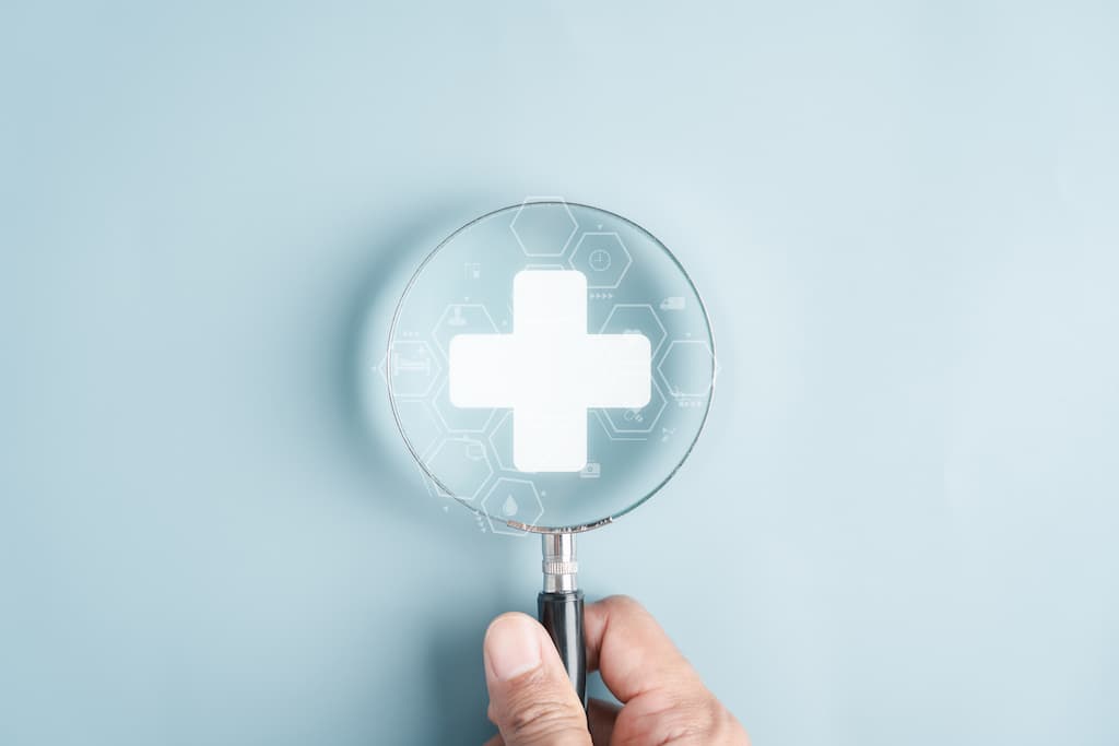Hand holding magnifying glass with white medical cross and hexagonal molecular patterns, representing peptide therapy safety research and medical oversight