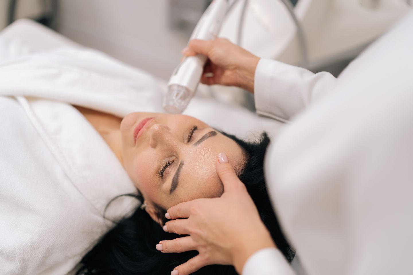 Woman relaxing during an RF microneedling facial treatment at a medical spa